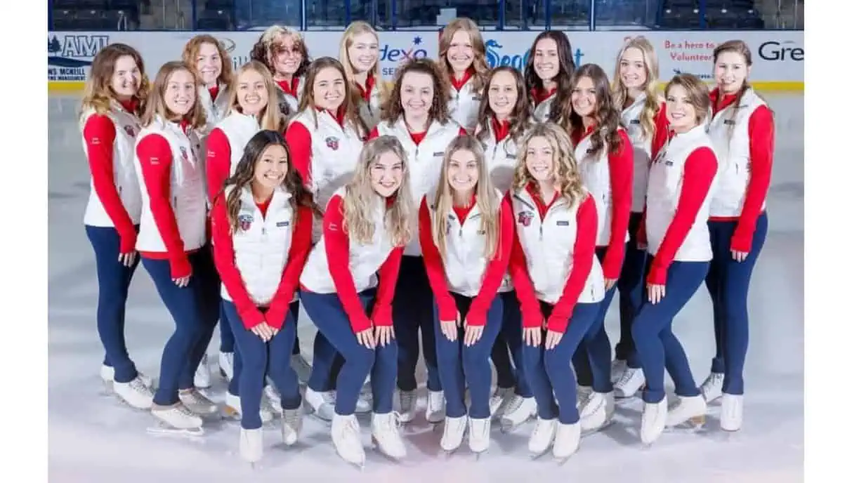 Liberty University's collegiate skating team wearing the team uniform of blue leggings, a red long-sleeved shirt and a white branded vest