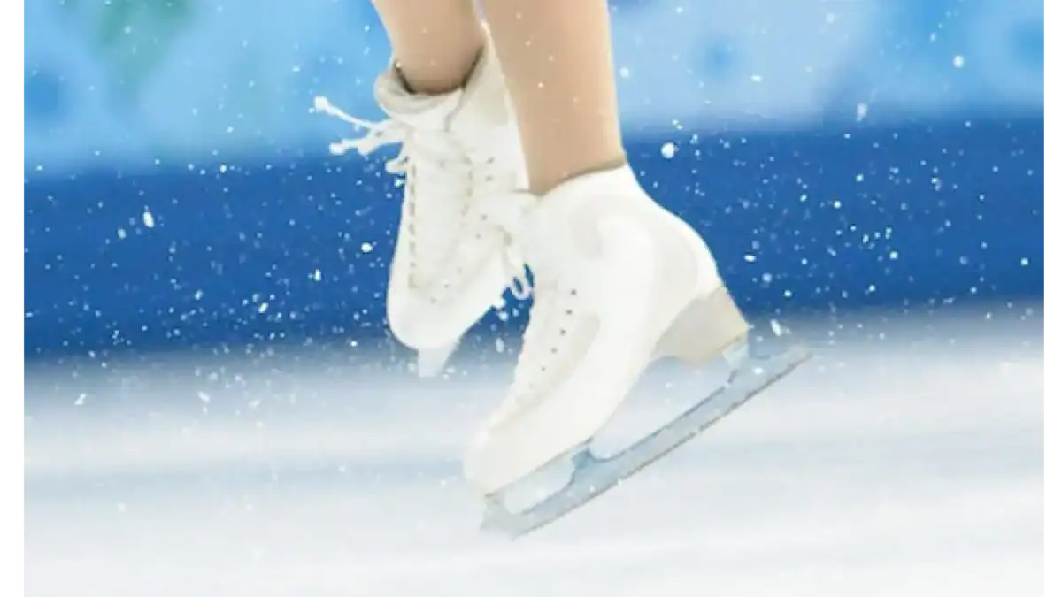 Close up of white figure skates crossed over each other in the middle of a jump