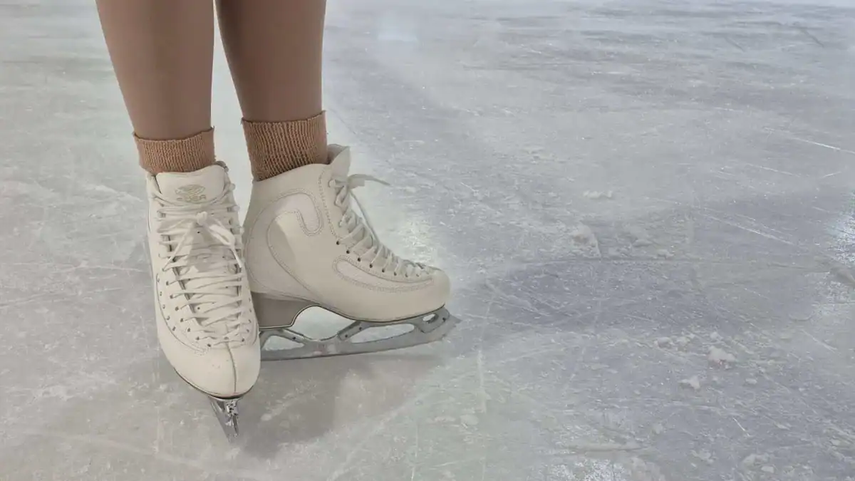 Close up of white figure skates in a typical testing V-type position ready to begin a test